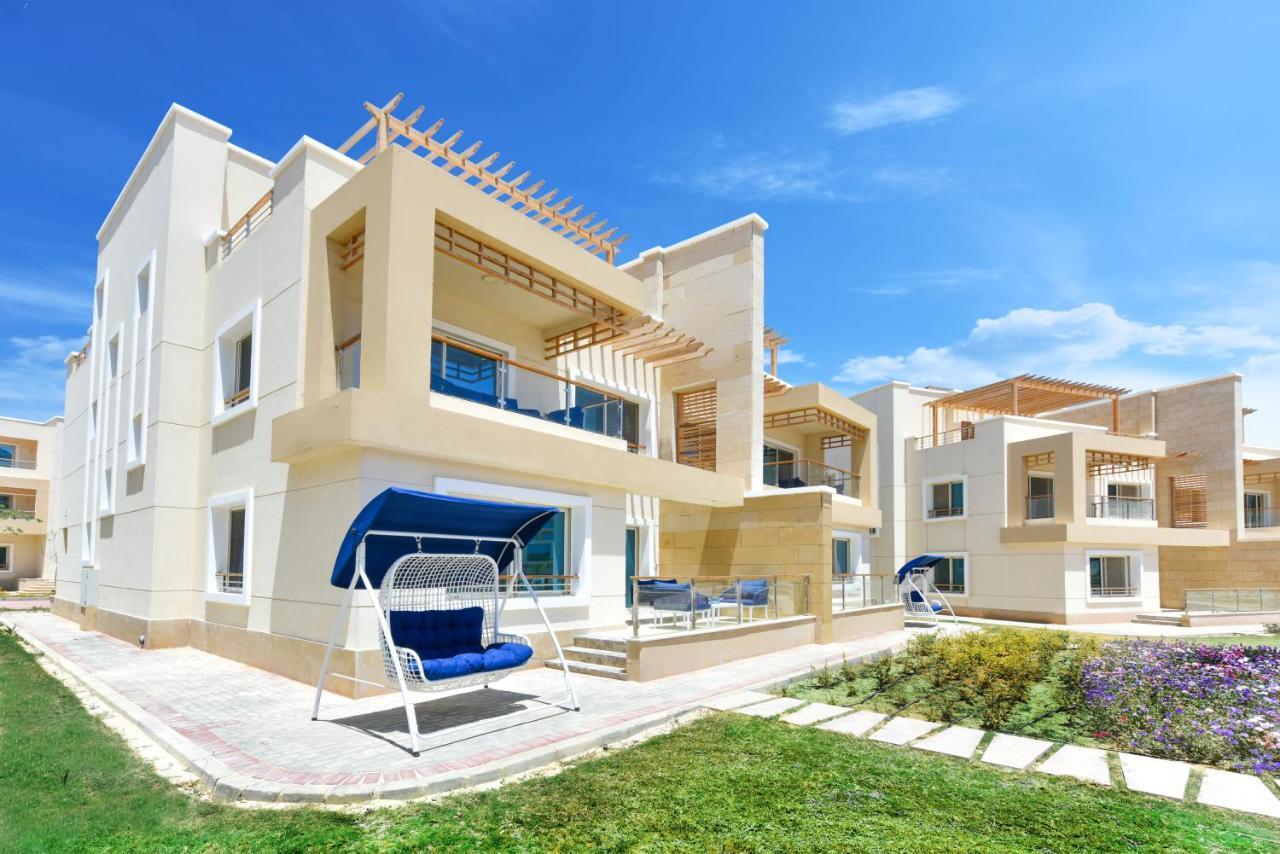 Tolip Resort El Galala Majestic Ain Sukhna Exterior photo The photo displays a modern residential complex featuring two or more white buildings with a contemporary architectural design. Each building has balconies, large windows, and a sunshine-friendly layout that maximizes natural light. In the foreground