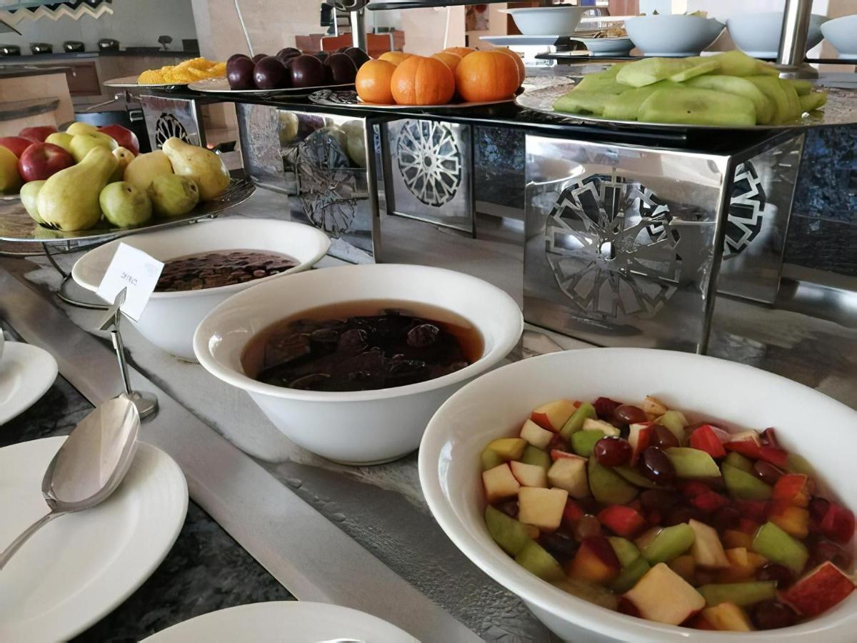 Tolip Resort El Galala Majestic Ain Sukhna Exterior photo The photo shows a buffet-style arrangement of various fruits and fruit dishes. In the foreground, there are several bowls containing different types of fruit. One bowl has a fruit salad made with diced apples, green apples, and possibly other fruits.